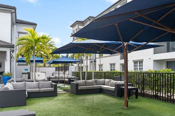 Outdoor courtyard couches poolside with umbrellas
